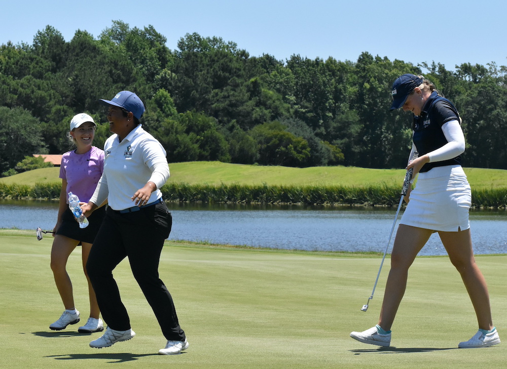 Mallory, on the right, walking off the green with fellow golfers